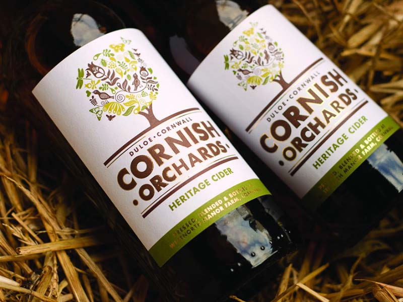 Two bottles of Cornish Orchard cider on a bed of straw