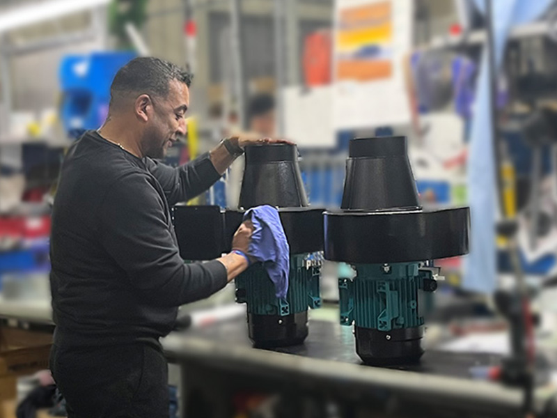 ACI technician assembling a custom fan unit in a workshop.